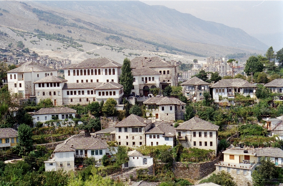 Traditional Ottoman stone houses of Gjirokastër, Albania set against mountain backdrop – Travel Crock
