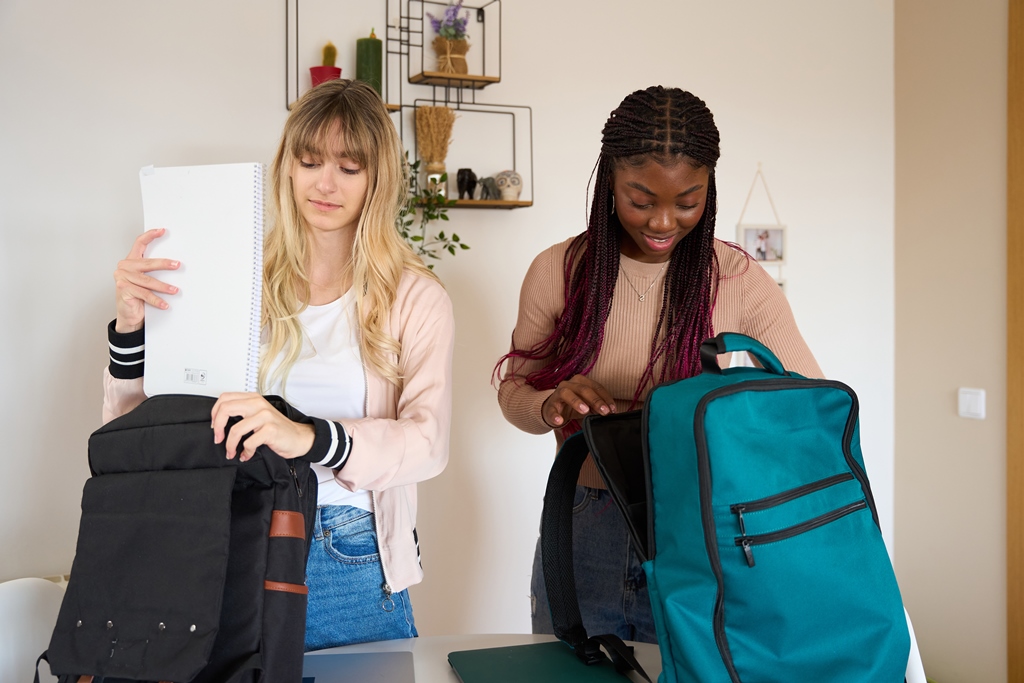 Two women preparing anti-theft travel backpacks at home—perfect for secure and organized travel with Travel Crock