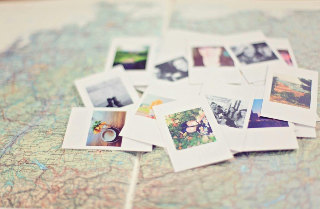 A collection of scattered polaroid travel photos placed on a detailed world map, evoking memories and inspiring wanderlust.